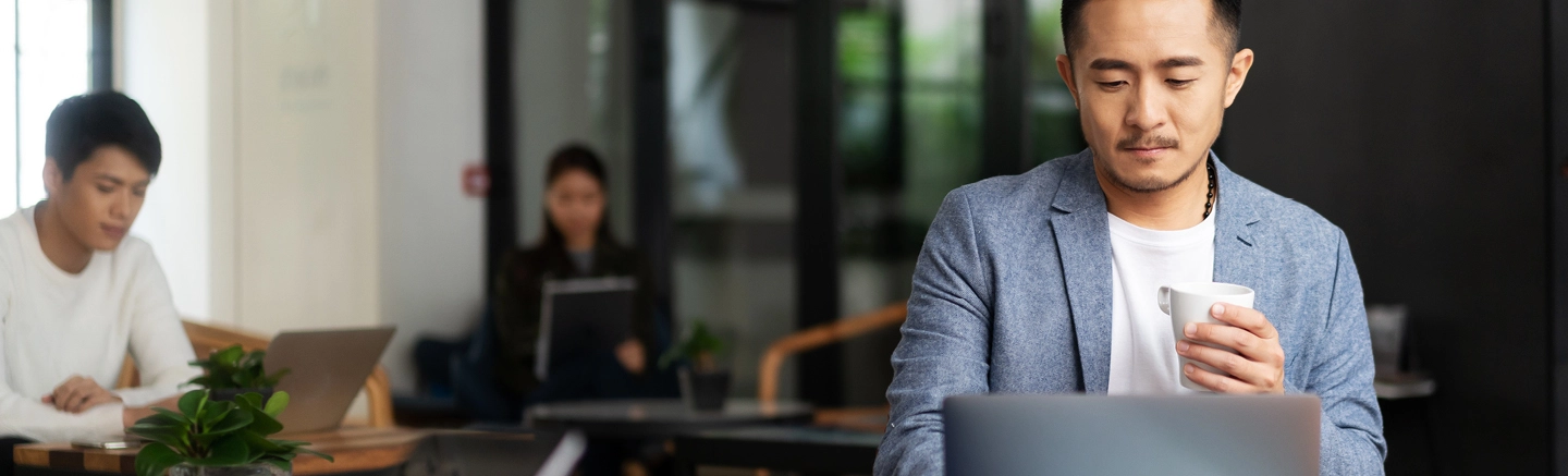 Man working on laptop and drinking coffee