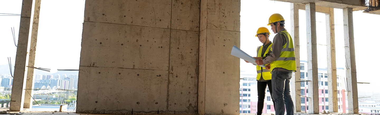 Man and woman on a building site wearing safety equipment