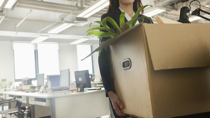 Woman carrying a box out of an office