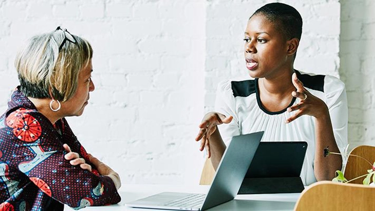Two women in workspace in discussion