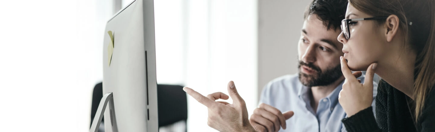 Man and woman looking at computer screen and talking